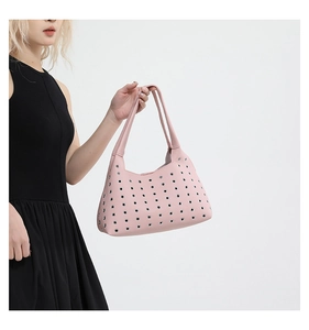Detail view of pink hollow rivet shoulder bag with silver eyelets and litchi texture