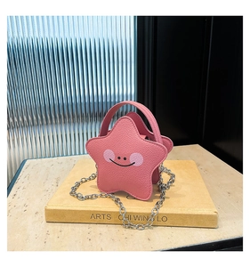 Detail of pink star-shaped mini bag in lychee faux leather with chain strap and smiley face