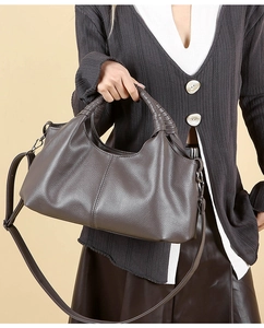 Detail of taupe litchi grain leather tote bag with round handles and adjustable strap
