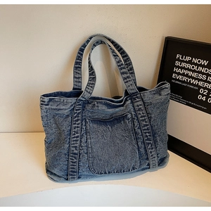 Detailed view of vintage washed denim tote bag featuring front pocket and sturdy handles
