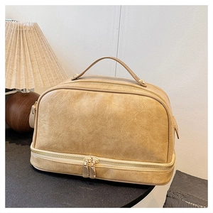 Detail of vintage double-layer makeup bag in khaki pleated PU leather with gold hardware