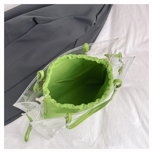 Top view of transparent PVC beach tote with bright green inner drawstring canvas pouch
