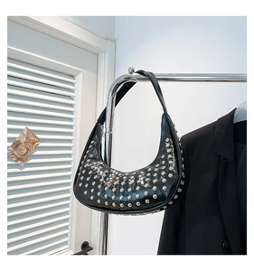 Detailansicht einer schwarzen Halbmond-Schultertasche mit silbernen Nieten und Glanz-Finish