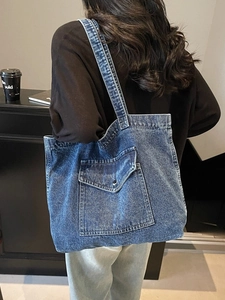 Large vintage blue denim tote bag with industrial front pocket and wide shoulder strap