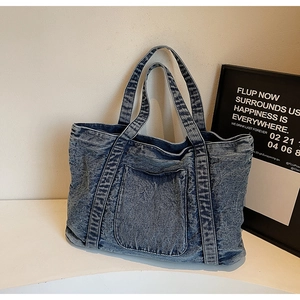Detail of vintage acid wash denim tote bag showing sturdy handles and large pocket