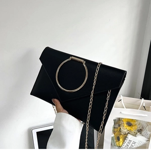 Détail de la pochette enveloppe en similicuir noir avec grand anneau doré et chaîne