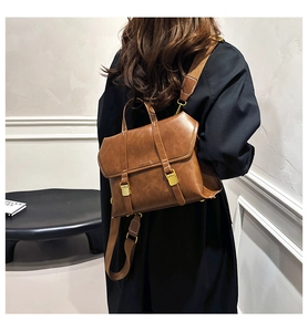 Macro view of brown vintage leather backpack with golden buckle and wide strap