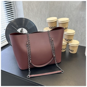 Detail of burgundy tote bag with leather texture and stylish chain shoulder strap