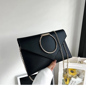 Détail de la pochette enveloppe en cuir PU noir avec grand anneau doré et chaîne