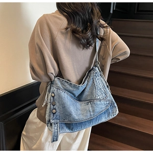 Detailed view of vintage washed denim hobo bag with retro metal buttons and belt accents