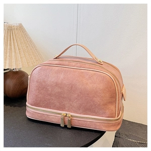 Detail view of pink PU leather makeup bag showing wide handle and golden hardware zippers