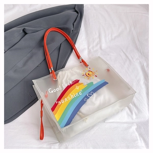 Detail of transparent beach tote with orange handles and Good luck Sunshine print