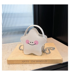 Close-up of a star-shaped white leather handbag with a smiley face and silver chain