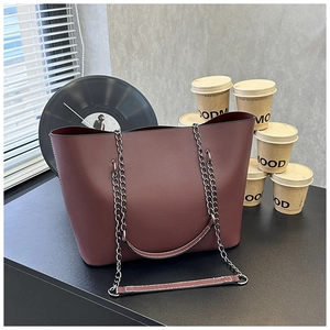 Burgundy tote bag with chain strap displayed in a stylish retro interior setting