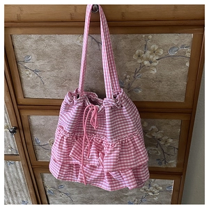 Detailed shot of pink and white checkered tote bag with ruffle trim and drawstring