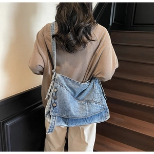 Detailed back view of a blue denim crossbody tote bag with metal button accents
