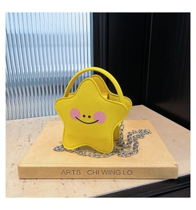 Detail of yellow star-shaped mini bag with smiling face and silver metal chain strap