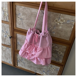 Detail of pink plaid canvas tote with layered ruffles and drawstring closure