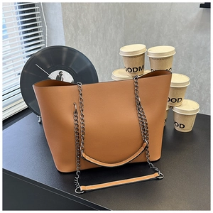 Close-up of brown litchi pattern leather tote with silver chain and leather shoulder strap