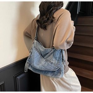 Detail of layered washed denim tote with metallic rivets and vintage pleats texture