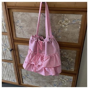 Detail of pink gingham tote bag featuring ruffled layers and a pink drawstring closure