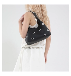 Detailansicht der schwarzen Achseltasche mit silbernen Nieten und Ösen-Hohlraum-Design