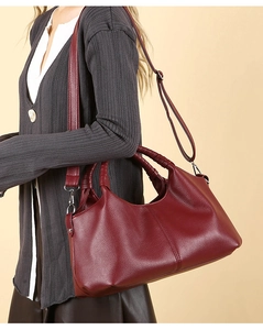 Close-up of burgundy leather tote bag showing detailed lychee grain and silver hardware