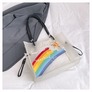 Close-up of frosted PVC beach tote featuring rainbow print and Good Luck lettering