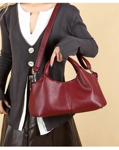 Close-up of burgundy leather tote bag featuring rich lychee texture and adjustable strap