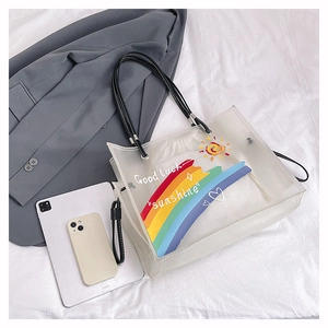 Detailed macro view of the waterproof PVC tote bag with rainbow prints and leather straps