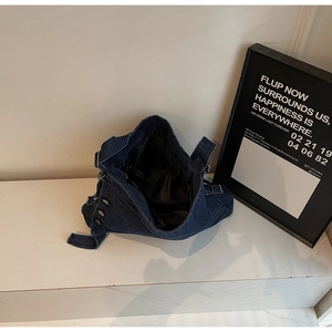 Detail view of large dark blue denim tote bag with silver buttons and black lining