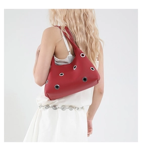 Modell mit roter Nieten-Unterarmtasche aus Leder mit silbernen Ösen und breitem Gurt