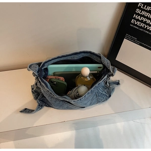 Macro shot showing large storage capacity for tablets and umbrellas in a denim tote bag