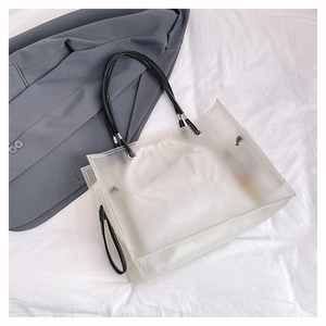 Macro detail of frosted PVC beach tote with white inner drawstring bag and leather straps