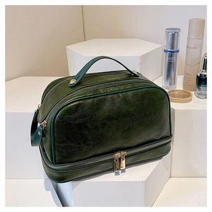 Macro shot of dark green double-layer travel toiletry bag with luxury gold zippers