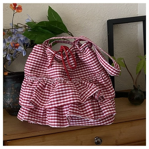 Detail of red and white checkered canvas tote bag with triple ruffled layers and drawstring