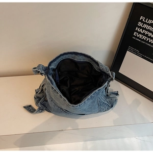 Detailed view of large denim tote bag featuring black lining and interior zipper pocket