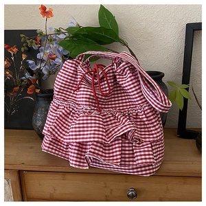Detail of red and white checkered tote bag featuring double-layered ruffles and drawstring