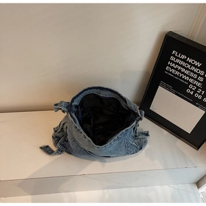 Detail view of denim tote bag showing black fabric lining and interior zipper pocket