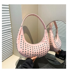 Detailaufnahme der rosa sichelförmigen Tasche mit silbernen Punk-Nieten und Reißverschluss