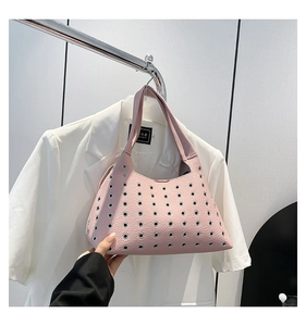 Detailed macro view of pink lychee textured leather underarm bag with metal eyelets