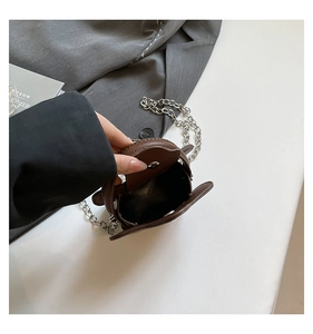 Detailed interior of brown pebbled leather mini bag with silver chain and magnetic clasp