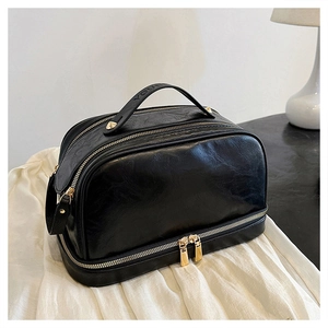 Detail view of black vintage makeup bag with double-layer design and golden zipper hardware