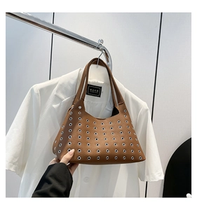 Detail of brown litchi pattern leather bag with silver metal eyelet rivet accents