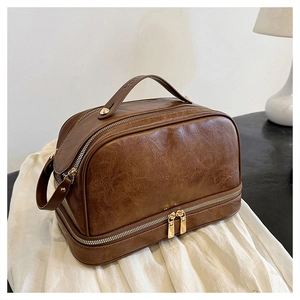 Close-up of vintage brown double-layer vanity bag showing PU leather texture and metal zippers