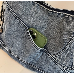 Detail of vintage denim tote bag featuring external pocket with a smartphone inside