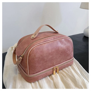 Detail view of pink PU leather makeup bag with dual compartments and gold metal hardware