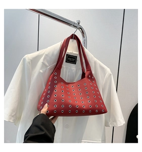 Detail of red pebbled leather underarm bag with silver rivet hollow-out design