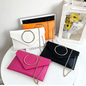 Détail de quatre pochettes enveloppes en orange, blanc, noir et rose avec anneaux dorés