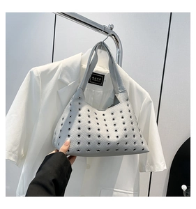 Detail of silver grey underarm bag with rock-style metal eyelet studs and lychee grain leather